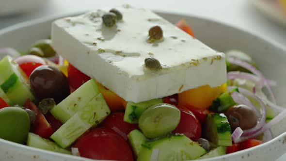 Olive Oil Dripping with Drops of Greek Rustic Village Horiatiki Salad with Whole Feta Cheese