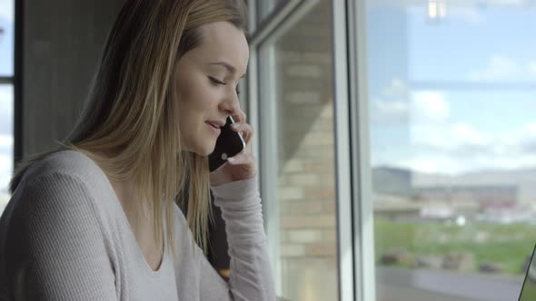 Young business woman talking on phone in shared workspace