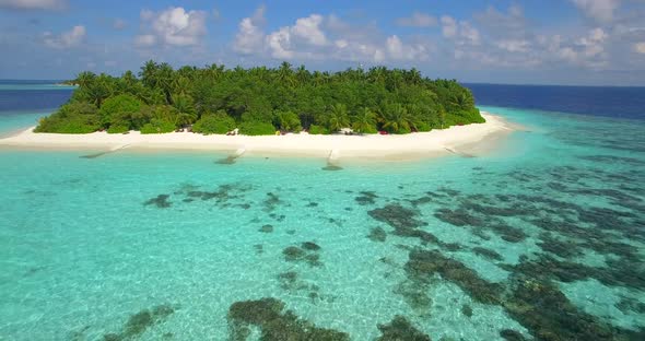 Aerial drone view of a man and woman couple kayaking around a tropical island alt