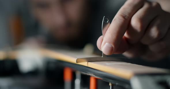 Luthier Checks the Fretboard Radius of the Electric Guitar After Sanding Repair of the Musical alt
