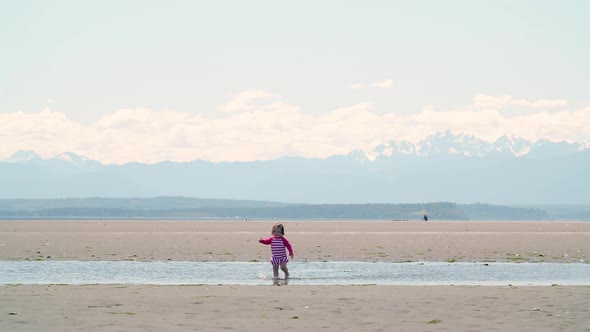 Toddler In Washington Beach Tide Flats With Mountains Background alt