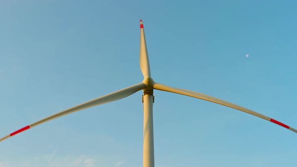Wind Turbine in an Offshore Wind Farm in the Green Field Against Low Sun on Sunrise the Closeup alt