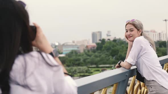 Asian lesbian couples enjoying traveling using film camera taking a photo.