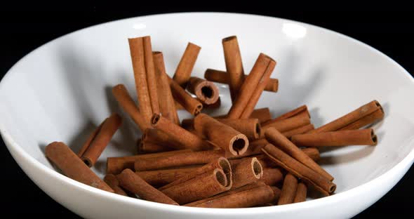 Cinnamon, cinnamomum zeylanicum, spice falling against Black Background, Slow Motion 4K alt