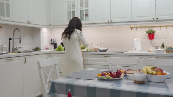 Woman Cooking Festive Dinner in the Kitchen Making Delicious Canape Topped with Red Caviar alt