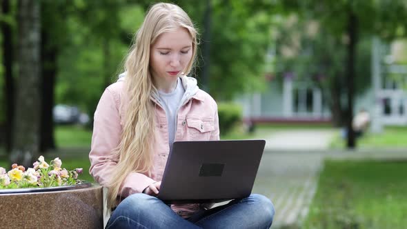 Young Blonde Girl Work on Laptop Computer at Park