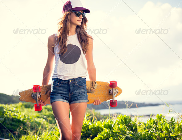 Beautiful young woman with a skateboard - Stock Photo - Images