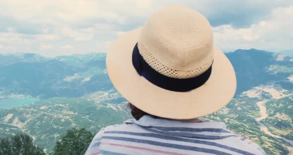 Closeup Woman Traveler Looking at Mountains View From Top alt