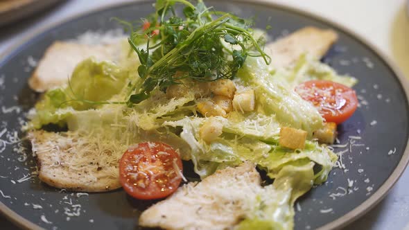 Delicious Caesar Salad Closeup on a Black Plate