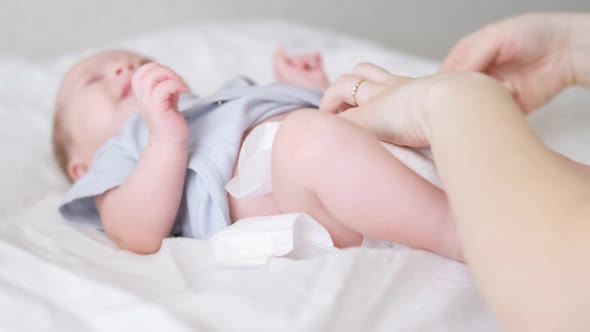 Mother Changes Diapers to Her Newborn Baby Little Boy on Changing Table in Clean Dry Nappy Mom alt