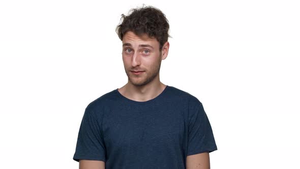 Portrait of Attractive Seductive Man Grinning and Showing Index Finger on Camera Meaning Hey you alt