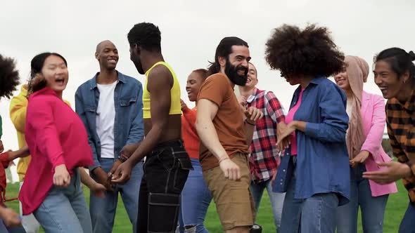 Diverse friends having fun dancing at city park - Concept of multiracial people and friendship