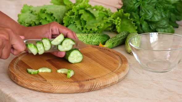 Woman hands cut fresh cucumber