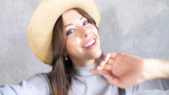Beautiful young trendy woman in hat. Girl smiling and looking on camera alt