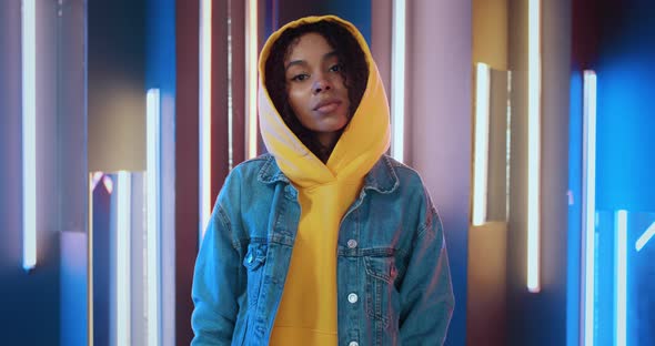Portrait of Stylish Urban African American Black Woman in Yellow Hoodie and Jeans Jacket Standing in alt