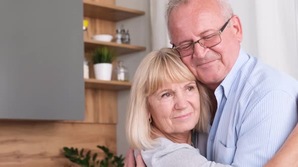 Happy Senior Couple Dancing at Home in the Kitchen They are Laughing and Hugging While Relaxing alt