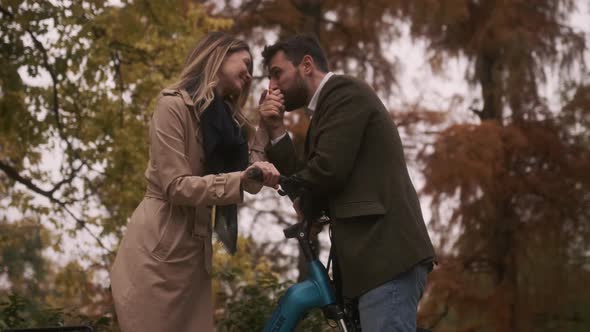 Handsome young couple in the autumn park with electrical bicycle