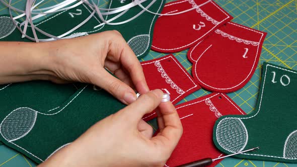 Woman creating Christmas Advent calendar for kids. Felt stockings and mittens