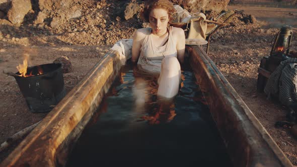 Woman Lying in Dirty Bath in Post Apocalyptic World alt