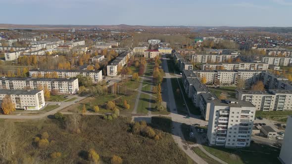 Aerial view of provincial autumn city with soviet panel houses, alley and house of culture 27 alt