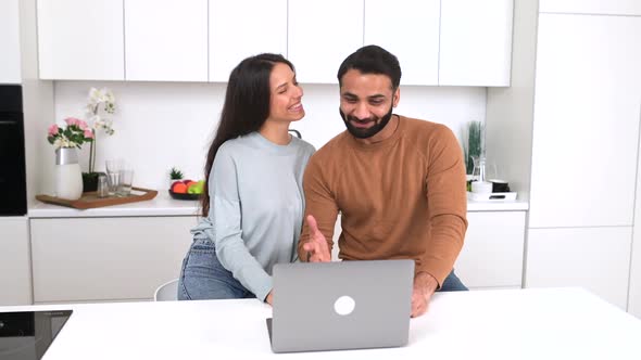 Cheerful Smiling Indian Couple Making Video Call Watching at Screen and Waving