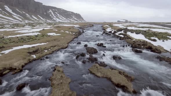 Winter landscape in Iceland with river and waterfall through the countryside