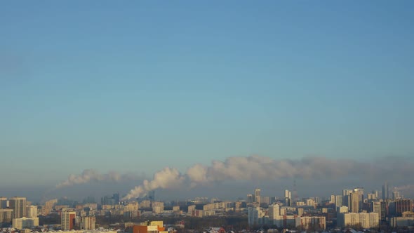 City Pipes Emit Steam Into the Atmosphere Against the City Skyline 2