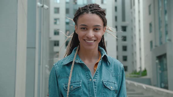 Portrait of Stylish African American Hipster Woman Standing on the Street Background alt