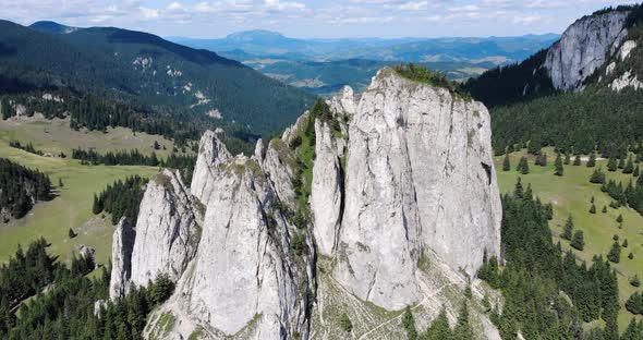 The Lonely Rock In The Hasmas Mountain. Piatra Singuratica Mountain Peak Above Evergreen Trees In Ro alt