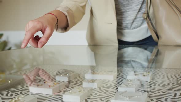 Close up of and of caucasian female touching glass surface, looking for jewelry alt