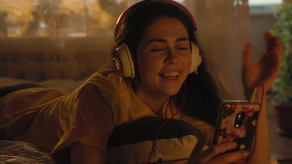 Portrait of a smiling woman communicating by video call on a smartphone.