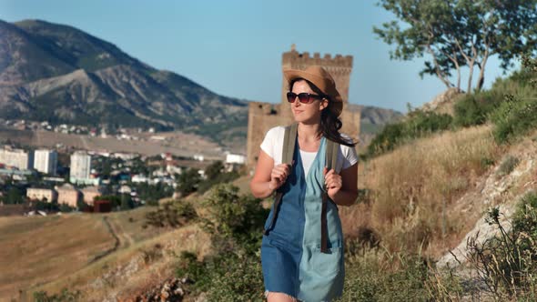 Attractive Backpacker Woman Enjoying Outdoor Activity Walking on Mountain Landscape at Sunset alt