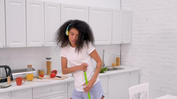 Woman Dancing and Singing, While Cleaning at The Kitchen