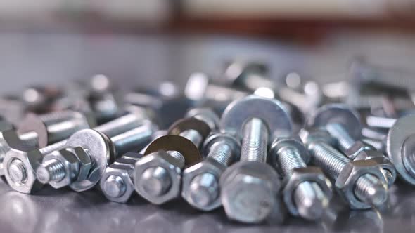 Slider Shot Video of Chrome Bolts and Nuts in a Chaotic Order Industrial Background alt