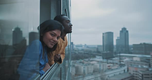 Multi ethnic couple enjoy view of city skyline alt