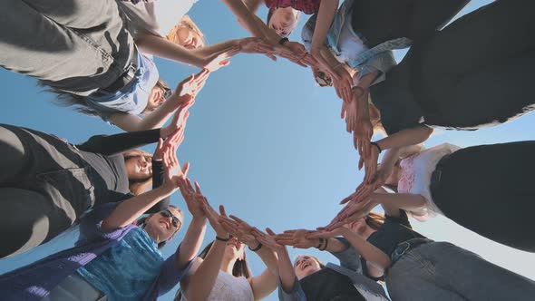A Group of Girls Makes a Circle From Their Palms alt