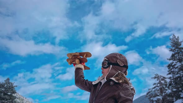 Happy Child Playing With Toy Airplane Against Winter Sky Background