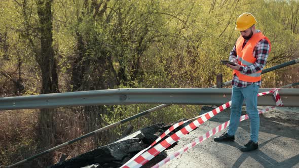 An Engineer in an Orange Vest and a Construction Control Helmet Conducts alt