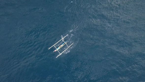 A Small White Boat Moving Swiftly in the Blue Ocean Aerial View. alt