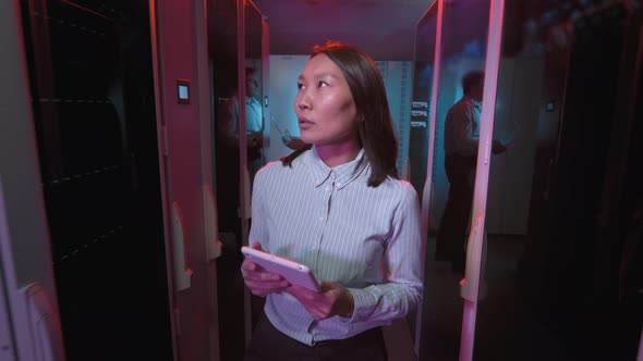 Asian Woman Checking Equipment in Data Center alt