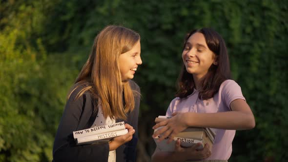 Medium Shot of Two Teenage Girls Laughing Gossiping Outdoors in Golden Sunlight alt
