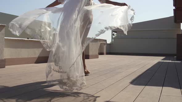 A Beautiful Bride in a Peignoir Walks on the Terrace. Girl in Beautiful Lingerie, the Wind Blows the