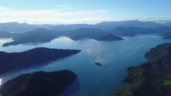 Aerial drone shot of seawater and islands with some boats. New Zealand alt