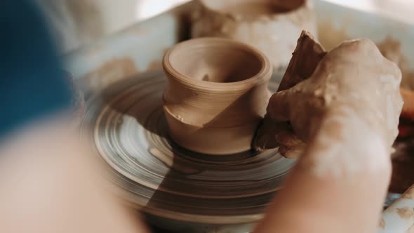 Hands of Woman Working on a Pottery Wheel. Creating a Ceramic Pot. Closeup. Arts Lessons and Pottery alt