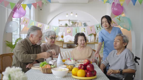 Group of Asian senior people celebrating birthday at retirement home with friends alt