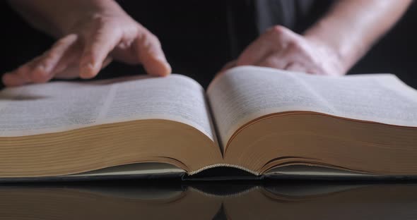 The Man Turns the Pages of the Textbook alt