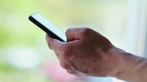 Side view. Hand of men using smartphone . Close-up of young man hand