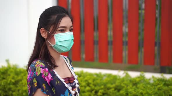 slow-motion of young woman in medical mask(surgical mask) walking outside a home alt