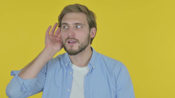 Young Businessman Trying to Listen Secret Yellow Screen alt