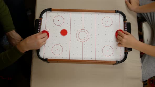 Father and Son Playing Table Air Hockey at Home